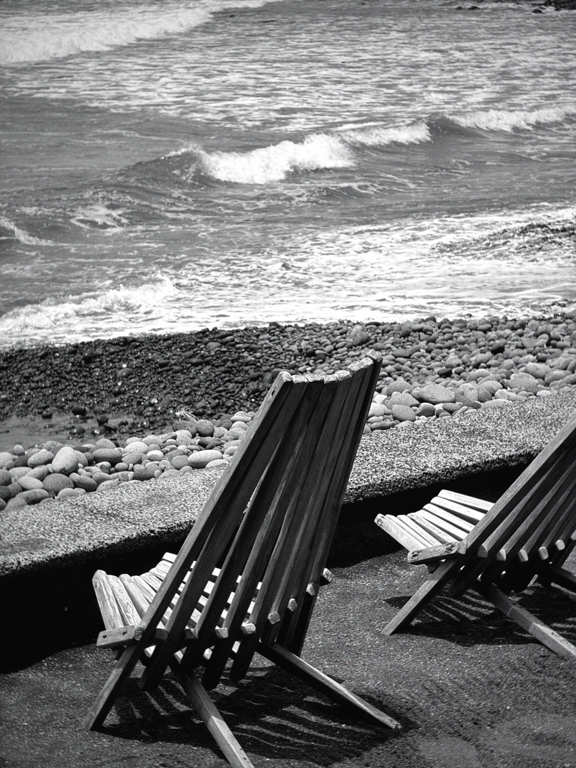 Sillas de madera frente al movimiento del mar